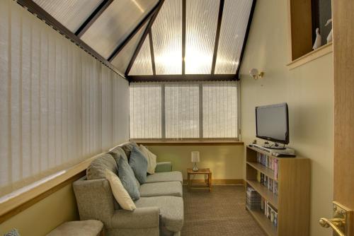 a living room with a couch and a tv at Kavija, Invergordon in Invergordon
