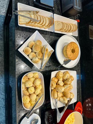 a table topped with plates of bread and pastries at Hotel Premier in Belo Horizonte