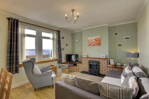 a living room with a couch and a fireplace at Kavija, Invergordon in Invergordon