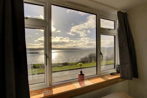 a window with a view of the water at Kavija, Invergordon in Invergordon