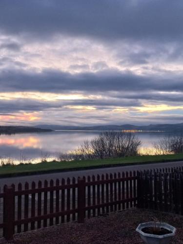 a view of a body of water with a fence at Kavija, Invergordon in Invergordon