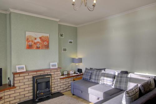 a living room with a couch and a fireplace at Kavija, Invergordon in Invergordon