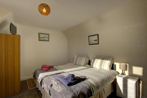 a bedroom with a bed and a tv on the wall at Kavija, Invergordon in Invergordon