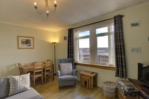 a living room with a couch and a chair and a table at Kavija, Invergordon in Invergordon