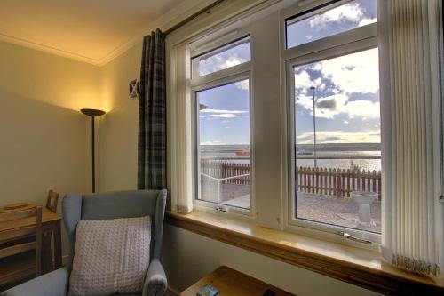 a bedroom with a window with a view of the ocean at Kavija, Invergordon in Invergordon