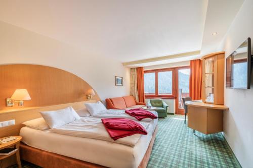 a hotel room with a bed and a couch at Der Kirchheimerhof - Superior in Bad Kleinkirchheim