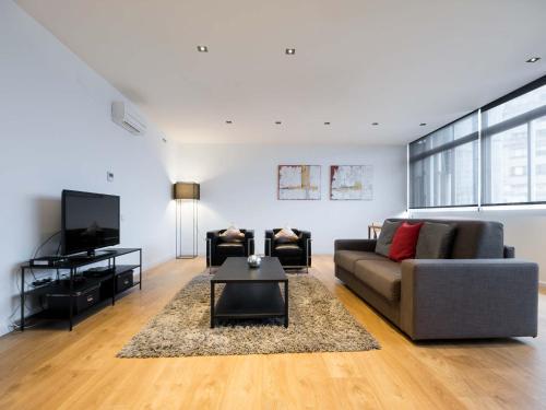 a living room with a couch and a tv at Rent Top Apartments Rambla Catalunya in Barcelona