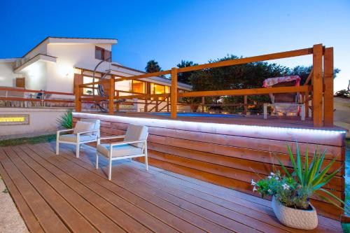 a deck with two chairs and a table on it at Appartamento in Villa con Terrazzo e Vista Golfo in Massa Lubrense