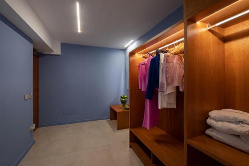 a walk in closet with a blue wall and clothes at Relais Manfredi in Castellammare di Stabia