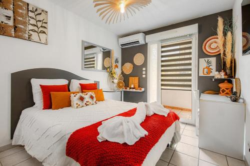 - une chambre dotée d'un lit avec une couverture rouge et blanche dans l'établissement Le Flamboyant du Fonserane - Climatisé, à Béziers