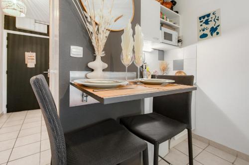 une petite cuisine avec une table et des chaises dans l'établissement Le Flamboyant du Fonserane - Climatisé, à Béziers