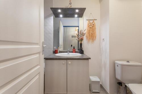 une salle de bain avec un lavabo et des toilettes dans l'établissement Le Flamboyant du Fonserane - Climatisé, à Béziers