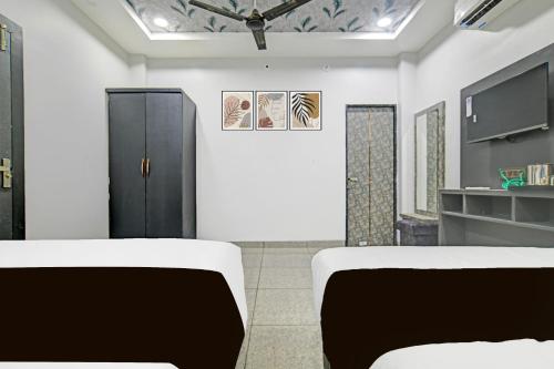 a living room with two chairs and a ceiling at Super Collection O Mahakal Formerly Maharana Pratap in Ujjain