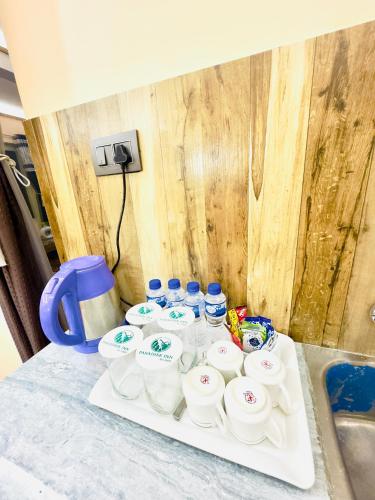 a bunch of cups on a tray on a counter at Paradise Inn by HBR in Dharmsala