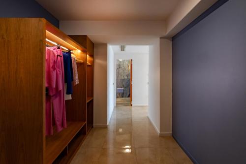 a hallway with a closet with pink clothes at Relais Manfredi in Castellammare di Stabia