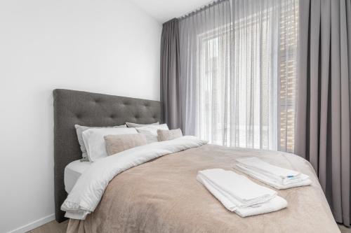 a bedroom with a large bed with two towels on it at Unbeatable Central Location - Reykjavíks Most Exclusive Luxury Apartments in Reykjavík