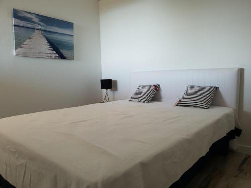 un lit blanc avec deux oreillers dessus dans l'établissement Appartement Playa del Oro résidence avec grande piscine et vue mer, à Conca