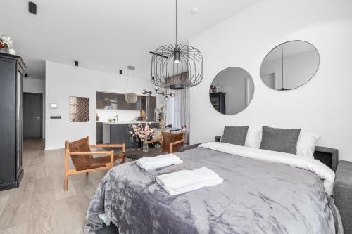 a white bedroom with a large bed and a chair at Unbeatable Central Location - Reykjavíks Most Exclusive Luxury Apartments in Reykjavík