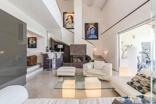 Elle comprend un salon doté d'un mobilier blanc et d'une cheminée. dans l'établissement Diane By Terrys Homes, à Cannes