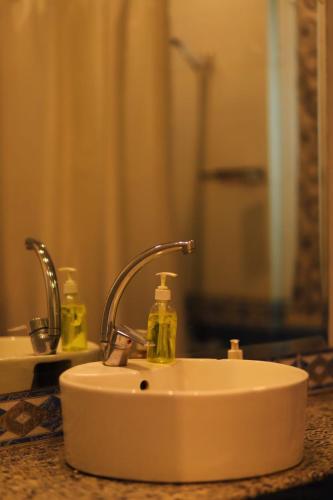 a bathroom sink with two soap bottles on it at غرفة أنيقة في قلب القاهرة in Cairo
