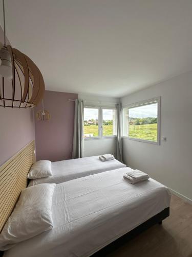 une chambre avec deux lits et deux fenêtres dans l'établissement Maison à louer au pays basque, à Anglet