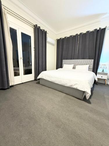 a bedroom with a large bed with black curtains at غرفة أنيقة في قلب القاهرة in Cairo