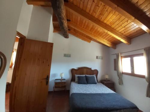 a bedroom with a bed and a wooden ceiling at Candela de la Murtera in Chelva