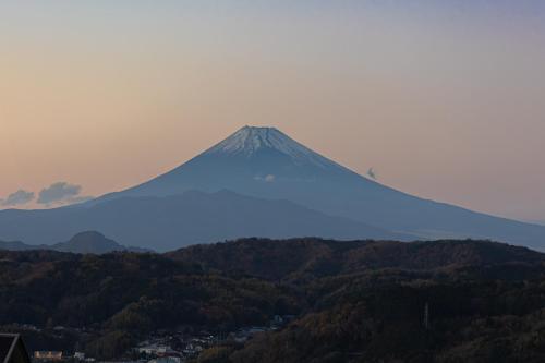 a mountain in the distance with a city and trees at 修善寺テラスヴィラ バレルサウナ付アウトドアリゾート in Izu