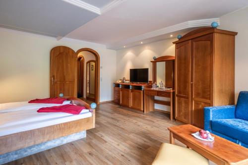 a bedroom with a bed and a blue couch at Der Kirchheimerhof - Superior in Bad Kleinkirchheim