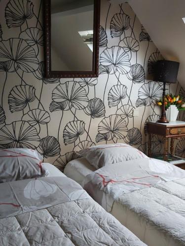 a bedroom with two beds and a wall with a mirror at b&b DE MANSARDE in Diest
