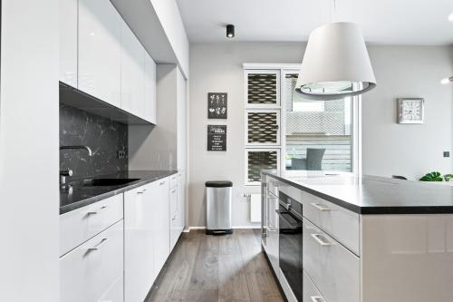 a kitchen with white cabinets and a black counter top at Unbeatable Central Location - Reykjavíks Most Exclusive Luxury Apartments in Reykjavík