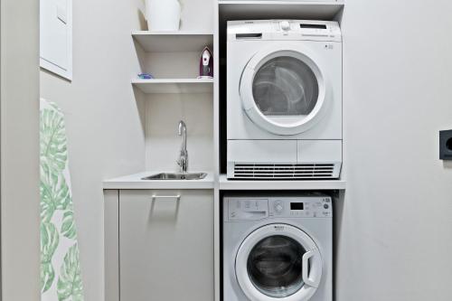 a kitchen with a washing machine and a sink at Unbeatable Central Location - Reykjavíks Most Exclusive Luxury Apartments in Reykjavík