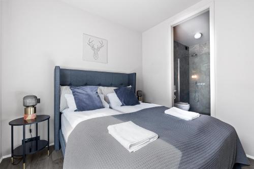 a bedroom with a large bed with blue pillows at Unbeatable Central Location - Reykjavíks Most Exclusive Luxury Apartments in Reykjavík