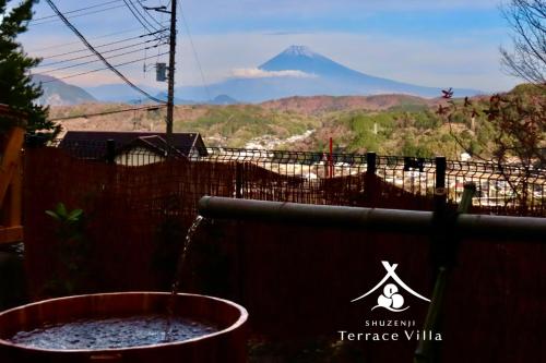 a view of a mountain in the distance with a bucket of water at 修善寺テラスヴィラ バレルサウナ付アウトドアリゾート in Izu