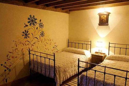 Un dormitorio con dos camas y una pared. en La Torre del Molino, en Tormellas