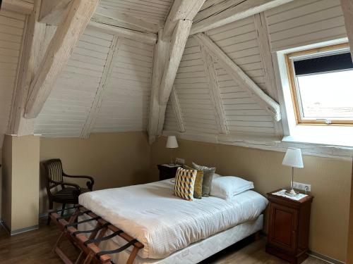 a bedroom with a bed and a large window at Auberge Le Meisenberg in Châtenois