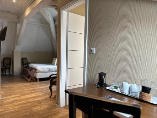 a room with a table and a bedroom with a bed at Auberge Le Meisenberg in Châtenois