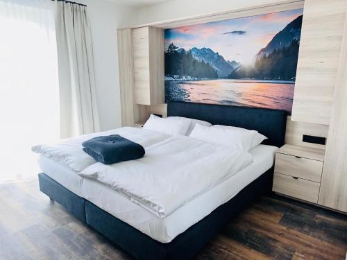 a bedroom with a large bed with a painting on the wall at Hotel Lainbach in Wängle in Reutte