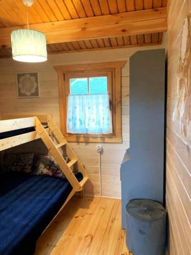a room with a bunk bed and a window at Pod Dziką Jabłonią in Debina