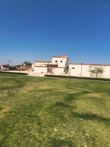 a field of grass with a building in the background at Lake view resort bikaner in Bikaner