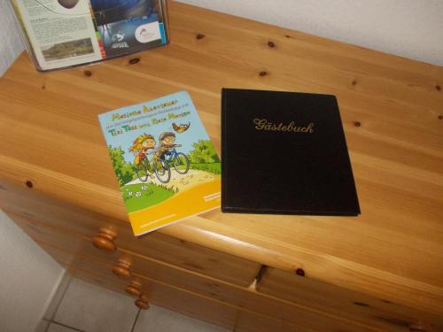 two books sitting on top of a wooden table at Finnhäuser am Vogelpark - Haus Elke in Marlow