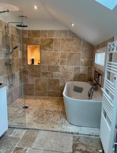 une grande salle de bain avec baignoire et douche dans l'établissement MAISON CENTRE D'ARNAGE idéal 24h du Mans et Le Mans classic, à Arnage