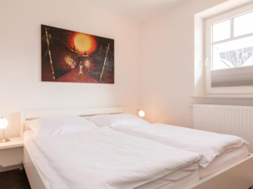 a white bed in a room with a window at Ferienwohnung Julian in Hörnum