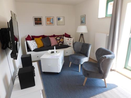 a living room with a couch and two chairs at Rektorscheune in Bad Sülze
