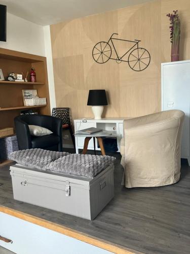Cette chambre comprend un lit, un bureau et un vélo sur le mur. dans l'établissement LE CID, à Saumur