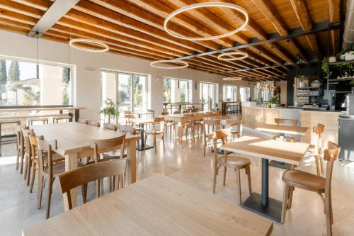 a restaurant with wooden tables and chairs and windows at Casa de Eli - Tenuta Torre Zecchei Wine Experience in Valdobbiadene