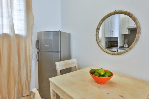 a kitchen with a table with a bowl of fruit and a mirror at Hanah Apartments by Living Essaouira in Essaouira