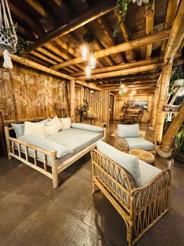 a bedroom with two beds and two chairs at Sidemen Luxury Nyan Bali - Bamboo House in Selat