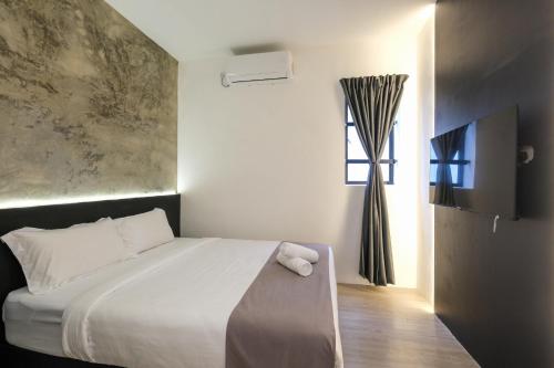 a bedroom with a white bed and a window at Loft 82 in Bukit Mertajam