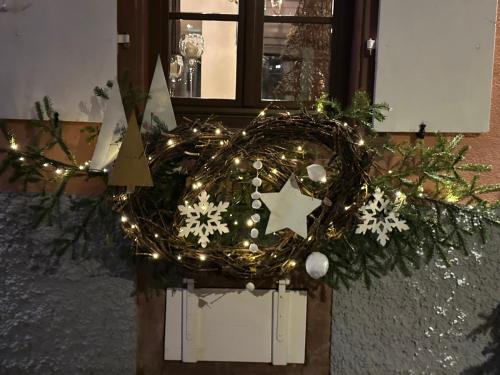 a wreath with christmas lights and snowflakes at Auberge Le Meisenberg in Châtenois